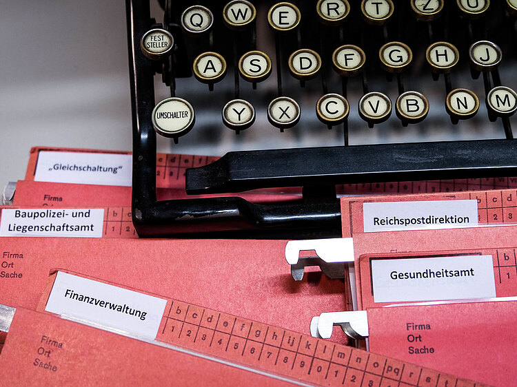 Material zum Workshop Verwaltung im Nationalsozialismus. EIne alte Schreibmaschine als Symbol und Arbeitsmaterial aus dem Workshop. Hier eine rote Mappe.