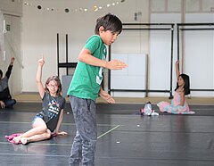 Kinder tanzen und amüsieren sich in unserem sozial-distanzierten Sommer-Workshop