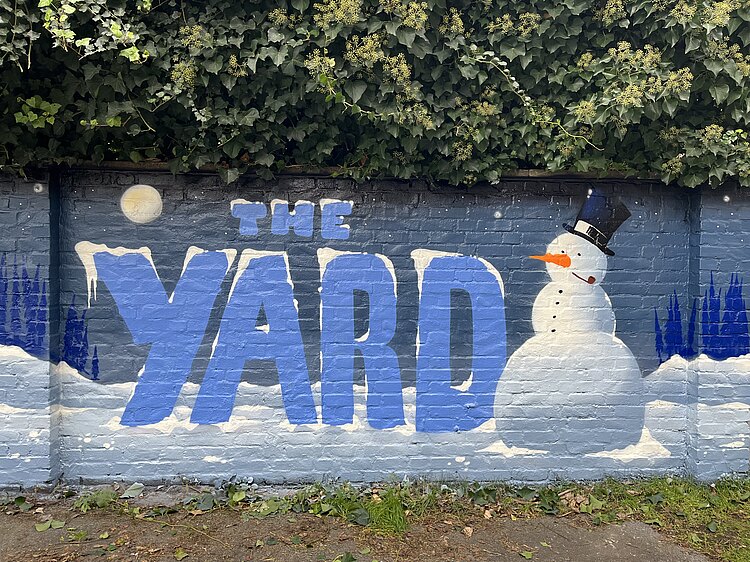 Graffiti mit dem Schriftzug "the yard" und einem Schneemann