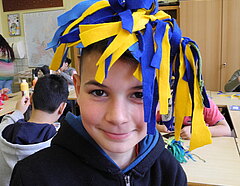 Junge mit gelb, blauen Kopfschmuck aus Filz.