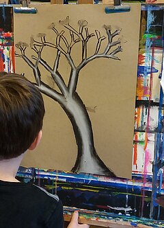 Junge malend an einer Staffelei