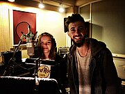 Mädchen und Junge hinter Mikrofon in Musikstudio