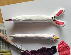 Zwei Bleistifte mit Ton umhüllt sehen aus wie ein Hase und ein Einhorn.