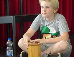 ein Kind mit Handtrommel, im Schneidersitz