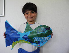 Junge mit Fisch aus Papier