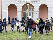 Eine Gruppe von Kindern rennt auf das Theatermuseum zu