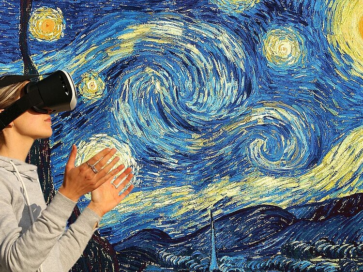 Frau mit VR-Brille schaut sich Van Gogh's Starry Night an