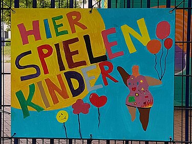 Kinder malten ein Plakat für ihren Spielplatz: bunte Ballons