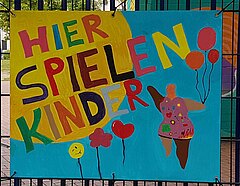 Kinder malten ein Plakat für ihren Spielplatz: bunte Ballons