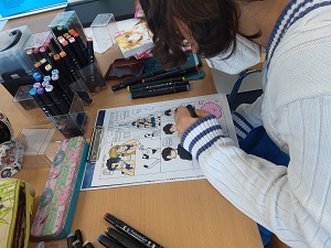 Mädchen malt ihren Comic bunt an